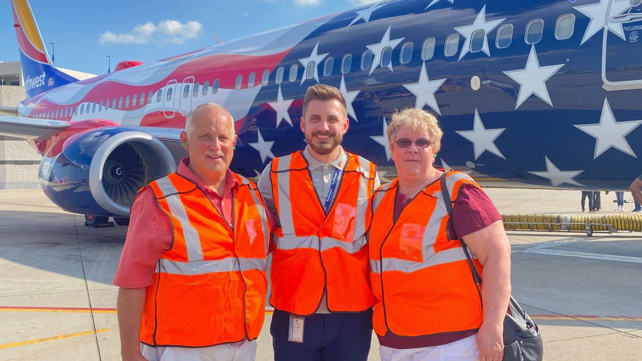 Southwest Airlines senior graphics designer Eric Daniels appears with his parents, Ohio residents Shirley and David Daniels, in front of Southwest’s Freedom One airplane, a Boeing 737-800 designed by Eric and emblazoned with a stylized American flag. (Southwest Airlines)